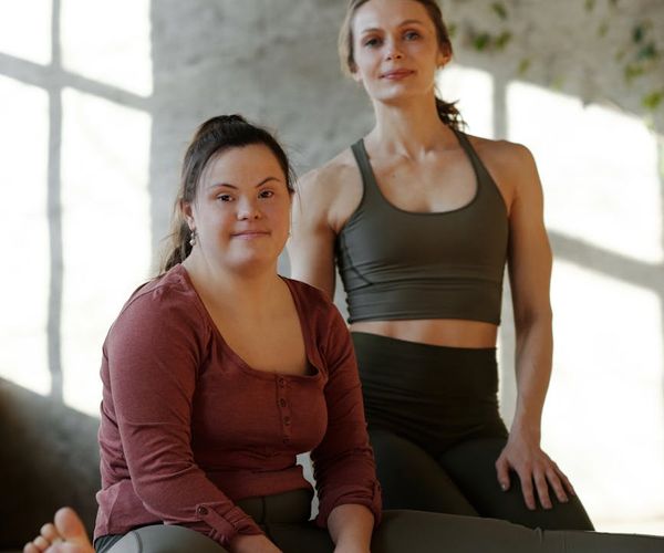 Person sitting cross-legged, meditating in a minimalist room.